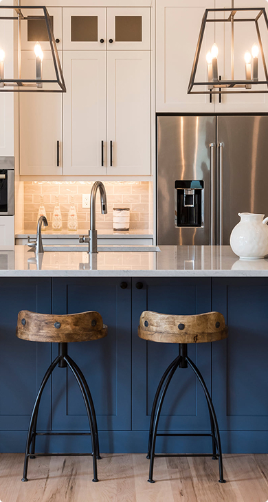 White kitchen with a navy blue island and wooden bar stools