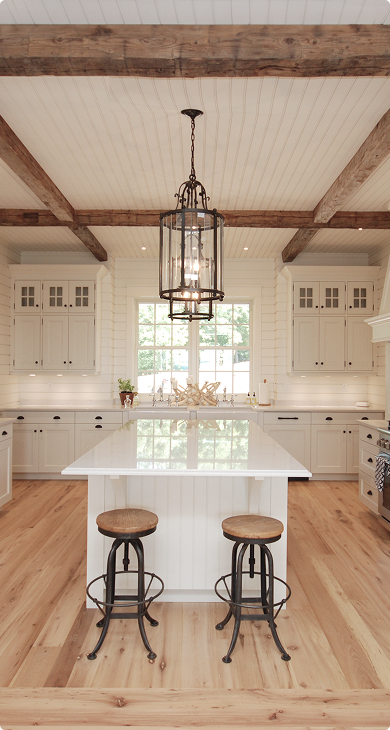 Farmhouse kitchen with exposed wood beams and a white island