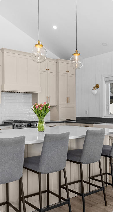 Cream shaker kitchen with a white quartz island and glass globe pendant lights